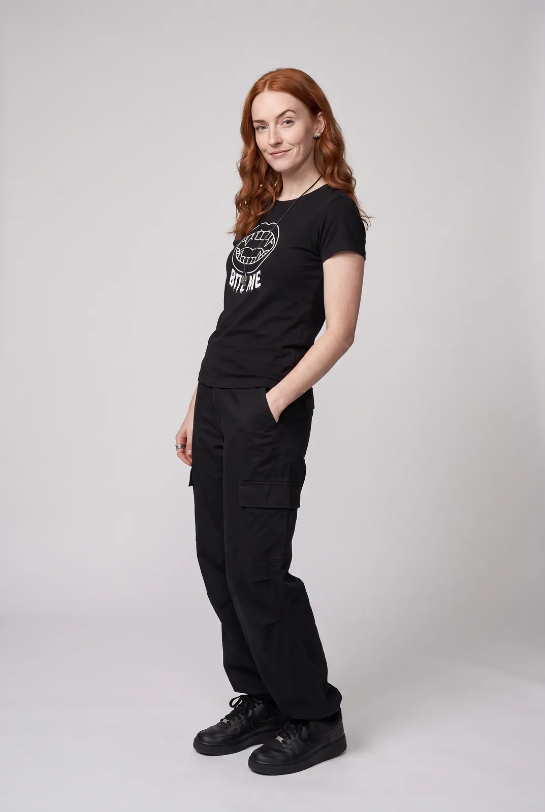 Maeve Gallagher wearing the BITE ME Tee in Black, three quarter lean