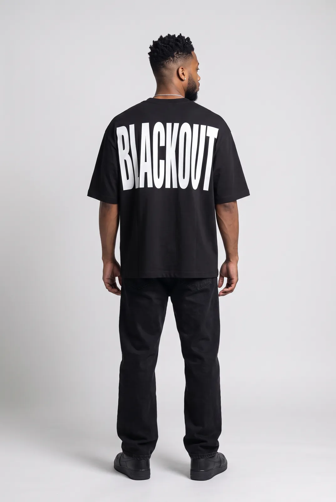 Malik Carter wearing the BLACKOUT Oversized in Black, back turn