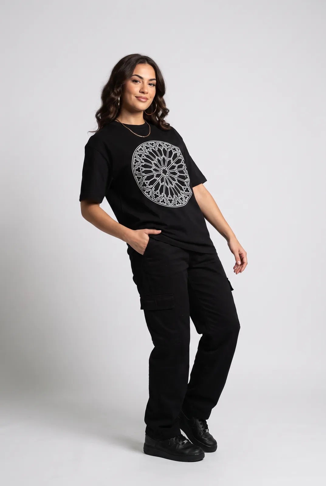 Amara Haddad wearing the CATHEDRAL Tee in Black, three quarter lean