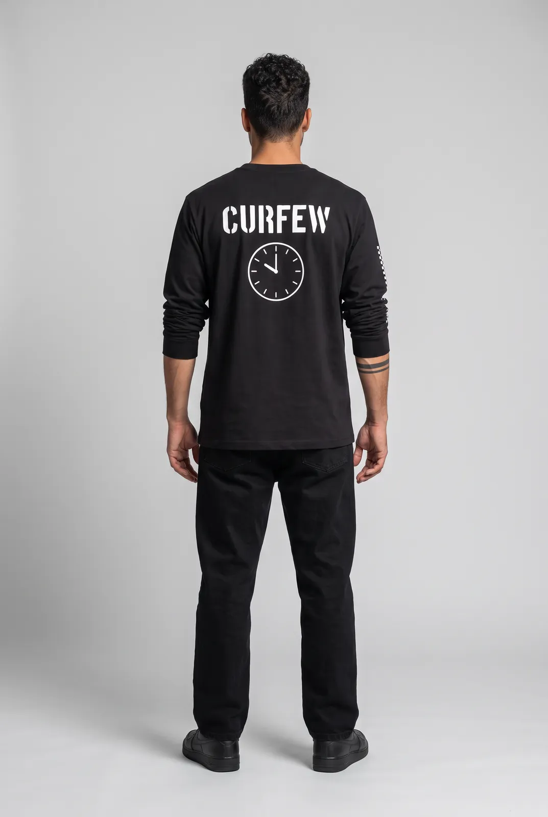 Diego Alvarez wearing the CURFEW Longsleeve in Black, back turn