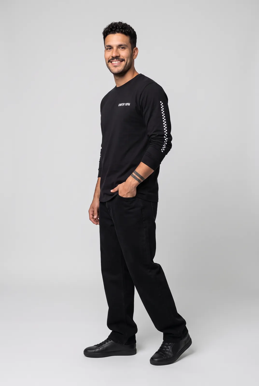 Diego Alvarez wearing the CURFEW Longsleeve in Black, three quarter lean