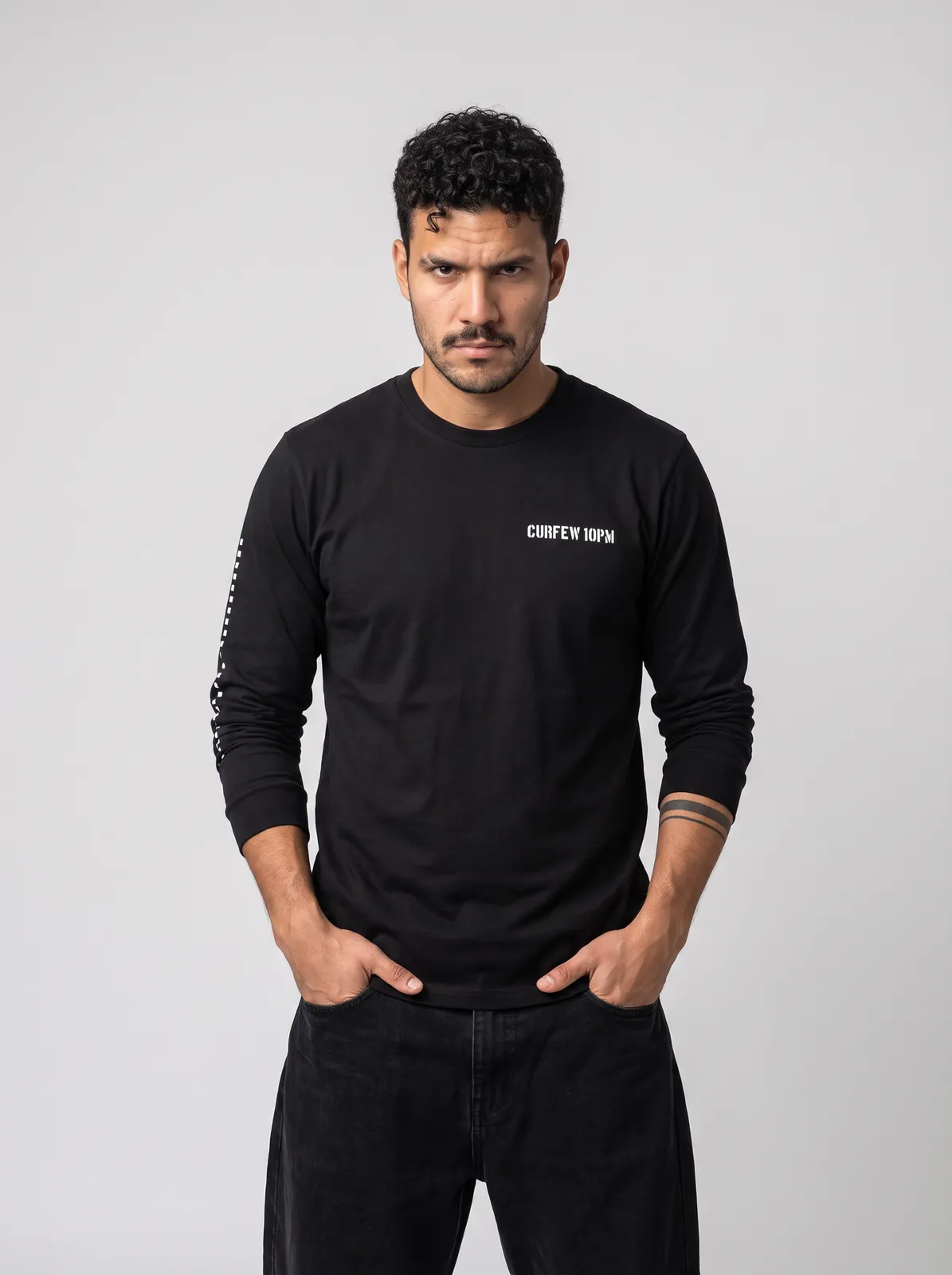 Diego Alvarez wearing the CURFEW Longsleeve in Black, waist up crop