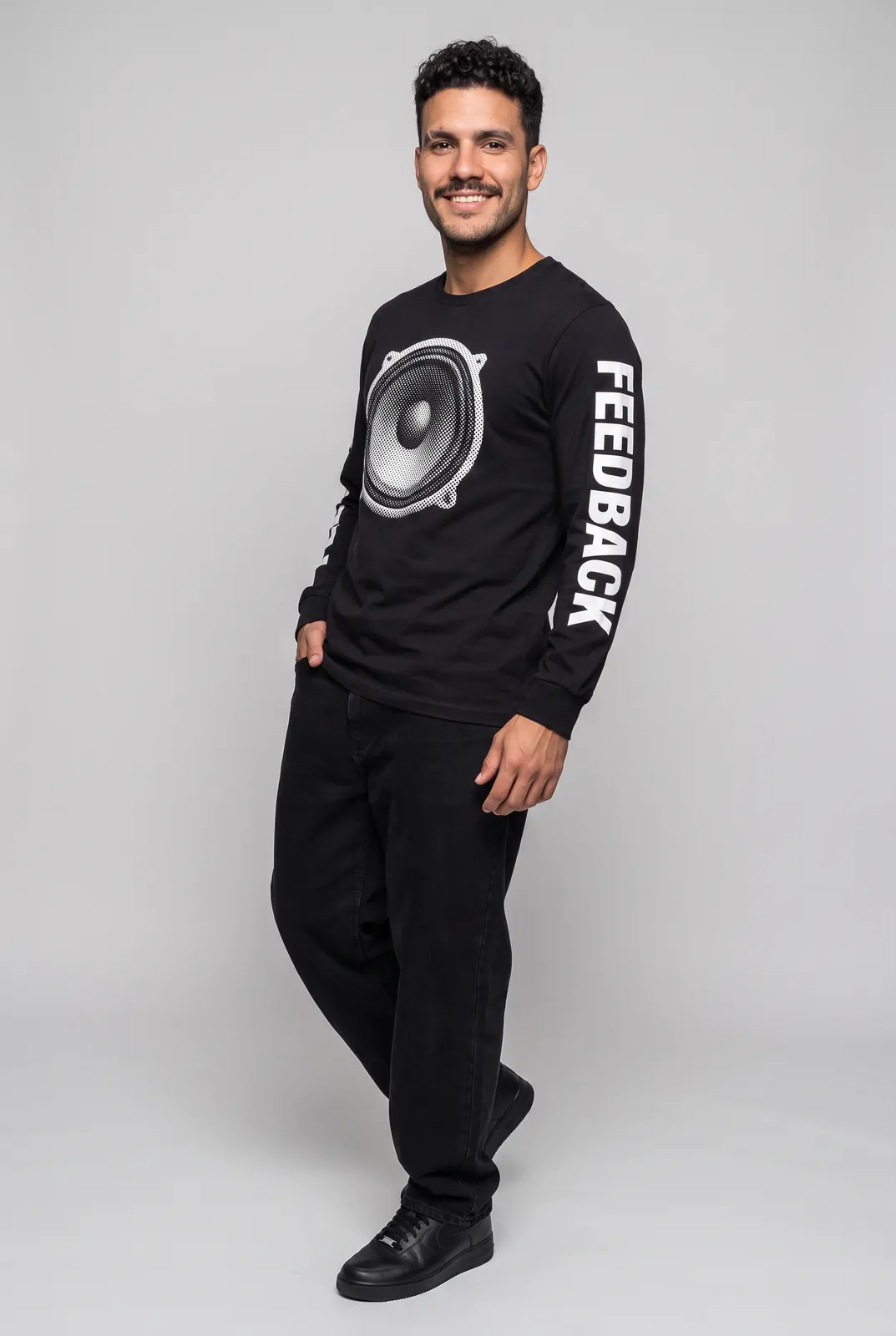 Diego Alvarez wearing the FEEDBACK Longsleeve in Black, three quarter lean