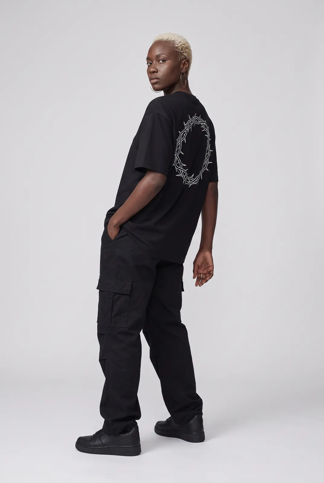 Imani Okafor wearing the HALO Oversized Tee in Black, three quarter lean