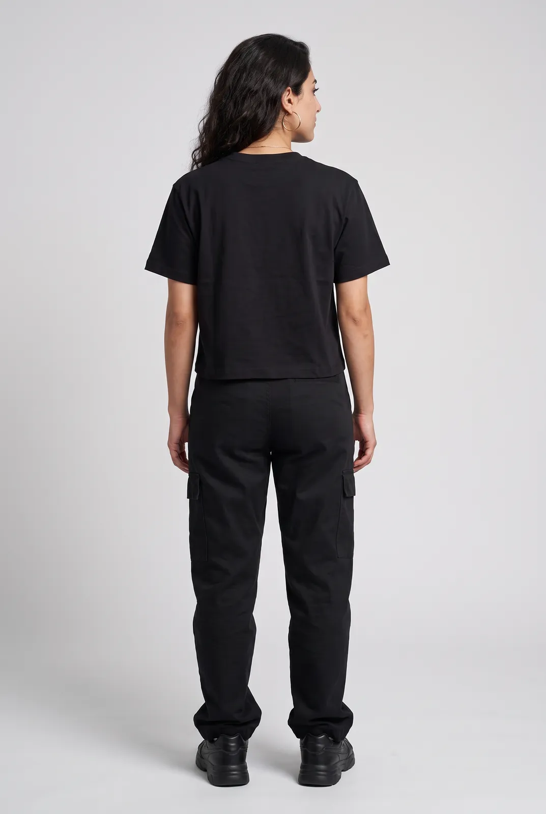 Amara Haddad wearing the HOTWIRE Cropped Tee in Black, back turn
