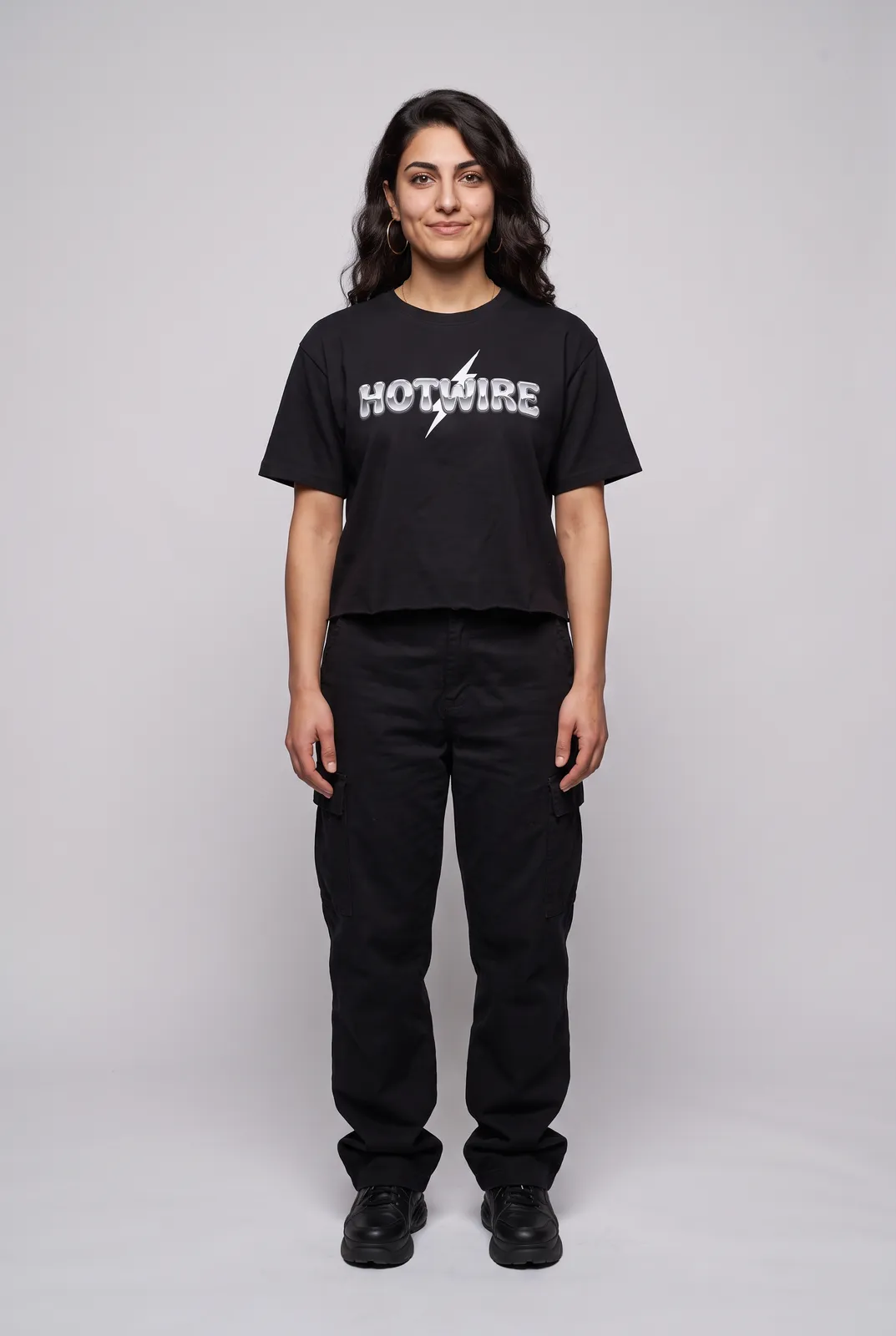 Amara Haddad wearing the HOTWIRE Cropped Tee in Black, front hero